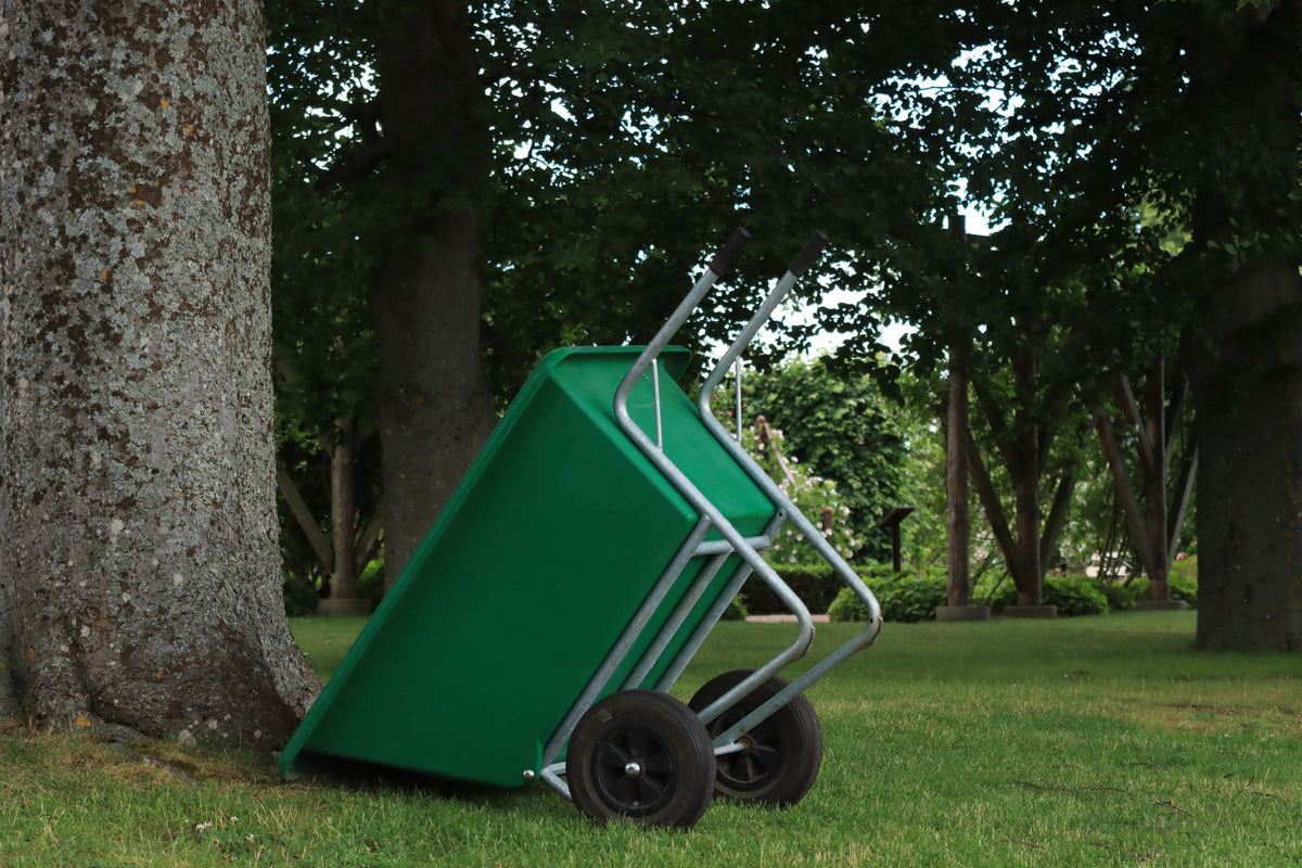 Kruiwagen op een verzorgd erf, gebruikt bij het onderhoud van stal en tuin